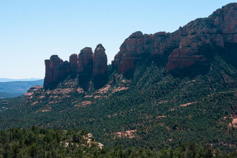 Coffee Pot Rock's sandstone spires rising above the forested Soldier Wash, seen from the edge of Brins Mesa, Sedona